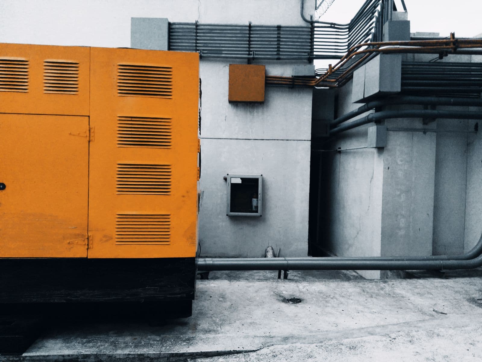 A standby generator enclosure installed beside a commercial building